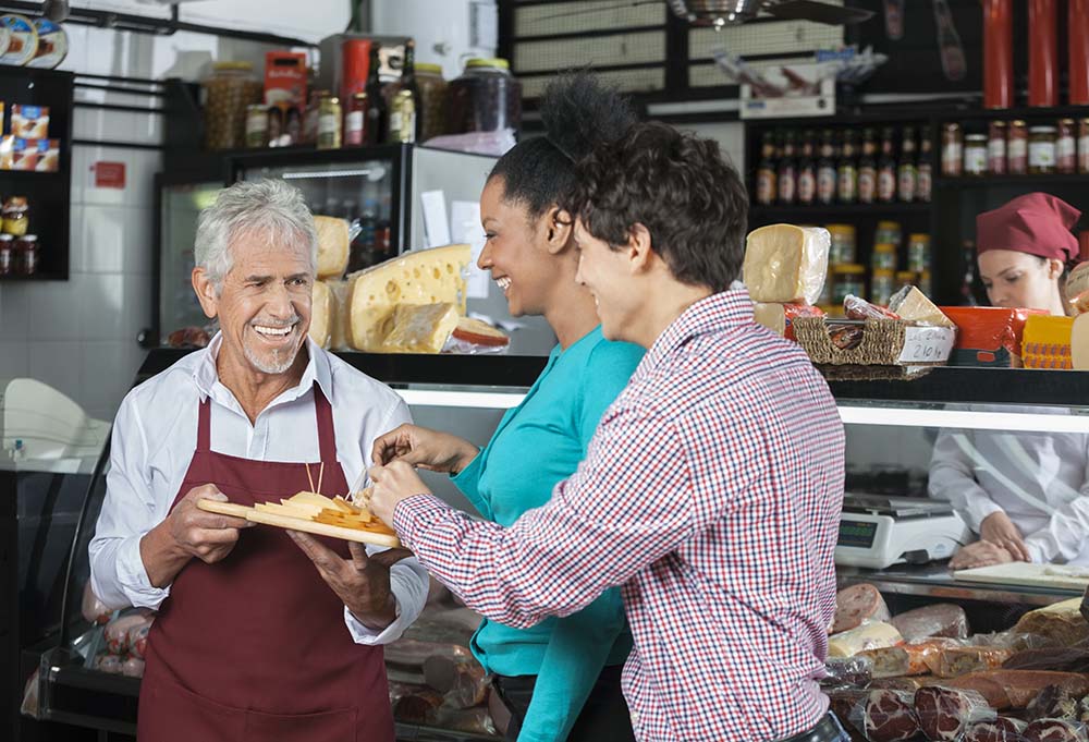 Animateur proposant du fromage à la clientèle d'une grande surface lors d'une animation commerciale en magasin